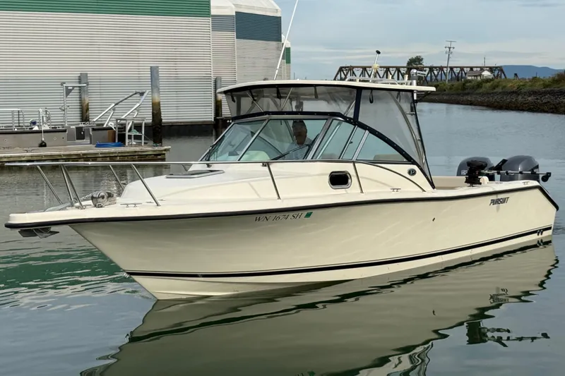 Slide: The Image of 2006 Pursuit 2570 Offshore boat docked in a marina, featuring twin engines. - 3