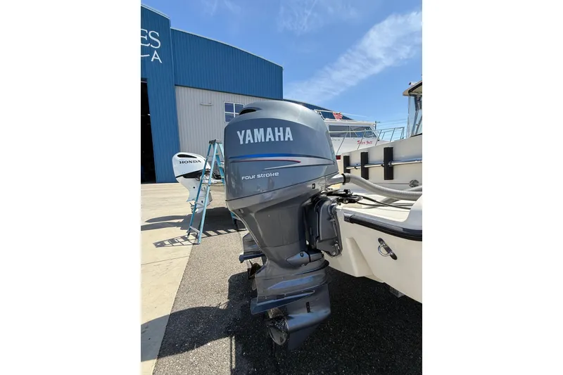 Slide: The Image of 2007 Pursuit 2570 Offshore boat with Yamaha four-stroke outboard motor in marina setting. - 58