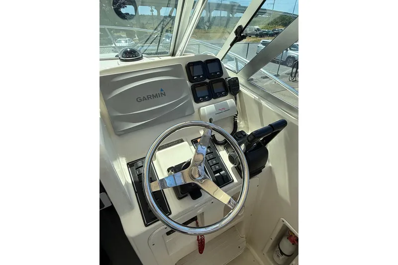 Slide: The Image of Helm of 2007 Pursuit 2570 Offshore boat with Garmin navigation system and steering wheel. - 46