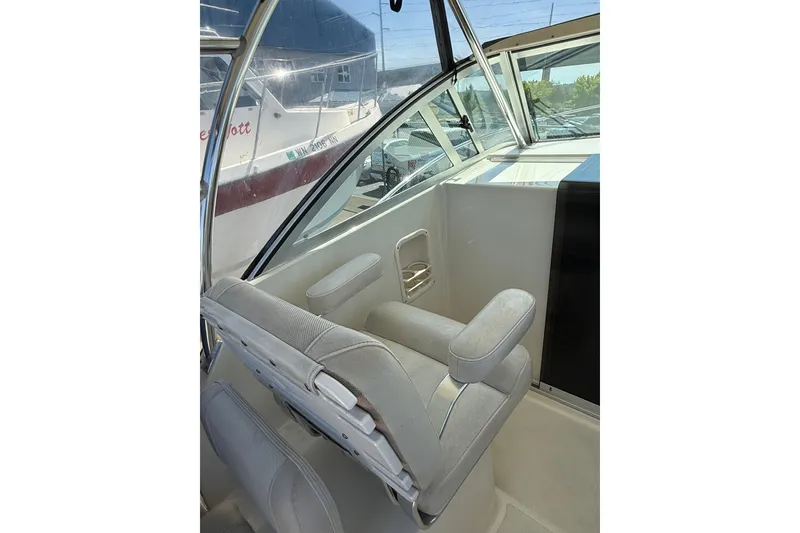 Slide: The Image of 2007 Pursuit 2570 Offshore boat interior with cushioned seating and window view. - 47
