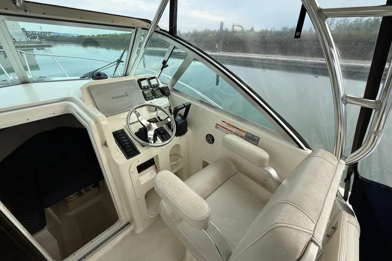 Slide: The Image of 2006 Pursuit 2570 Offshore boat cockpit with steering wheel and Garmin navigation system. - 9