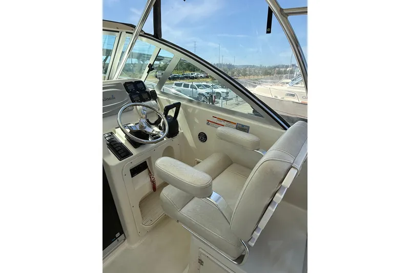 Slide: The Image of 2007 Pursuit 2570 Offshore boat cockpit with steering wheel and control panel. - 10