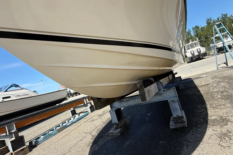 Slide: The Image of 2007 Pursuit 2570 Offshore boat on dry dock, viewed from below, with clear blue sky. - 54