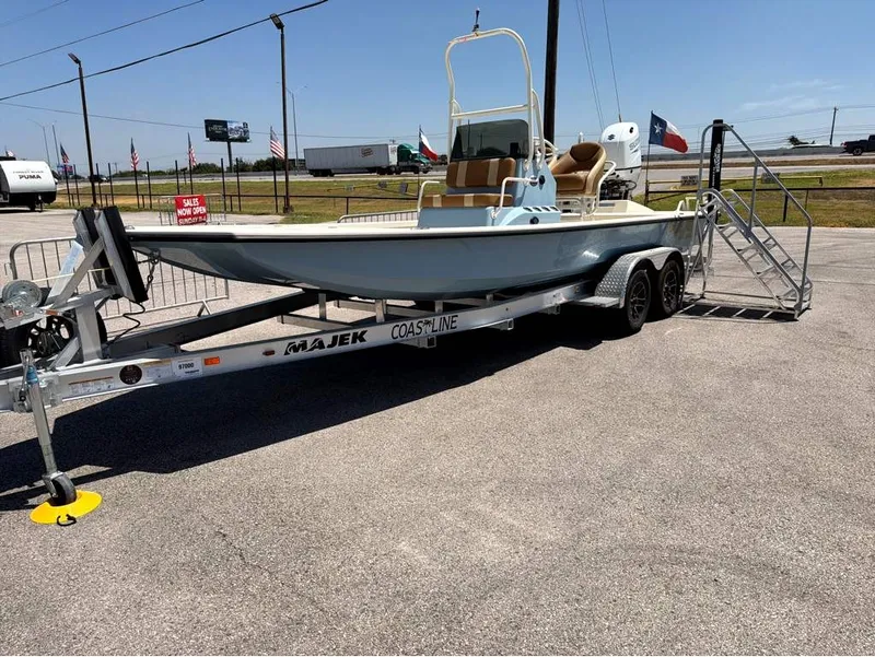 The Image of A 2027 Majek 22 Illusion boat on a trailer, parked in a lot. - 1