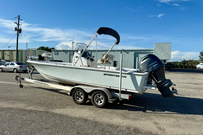 Slide: The Image of 2015 Sportsman Masters 227 Bay Boat on trailer, parked outdoors under clear sky. - 1