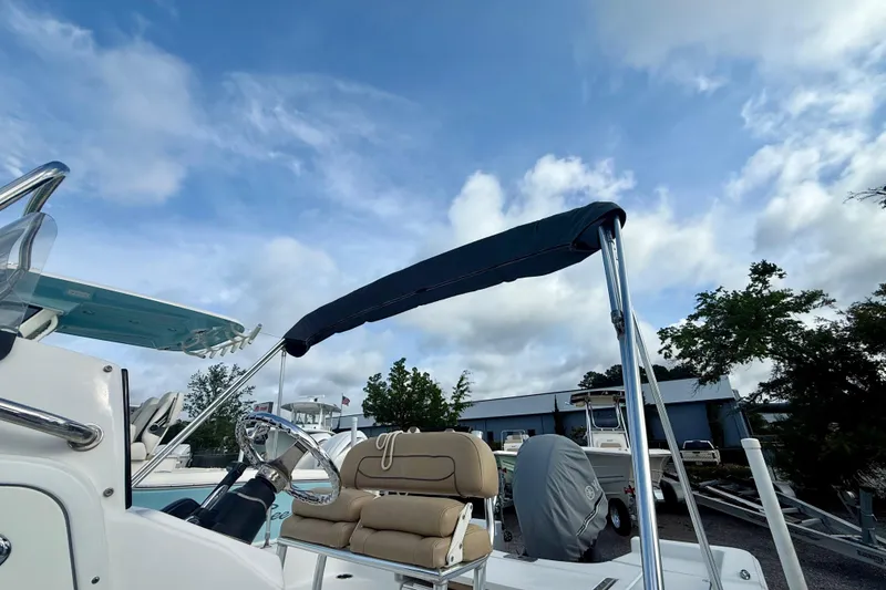 Slide: The Image of 2015 Sportsman Masters 227 Bay Boat with canopy under a cloudy sky. - 6
