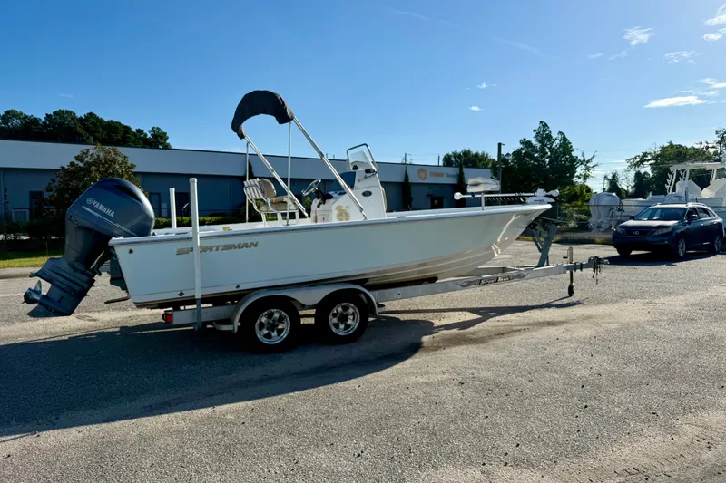 Slide: The Image of 2015 Sportsman Masters 227 Bay Boat on trailer, parked outdoors under clear sky. - 2