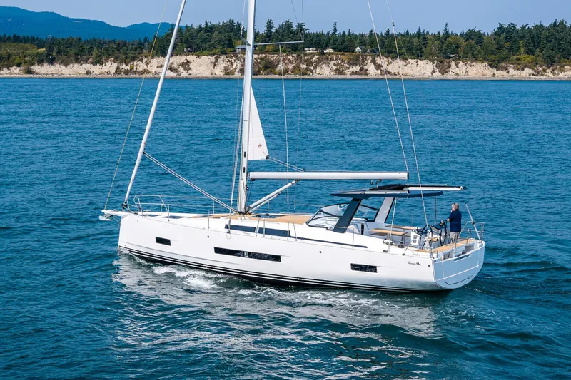 Slide: The Image of 2025 Hanse 460 yacht sailing on blue ocean near scenic coastline. - 3