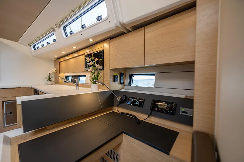 Slide: The Image of Modern interior of 2025 Hanse 460 yacht with sleek kitchen design and natural wood finishes. - 18