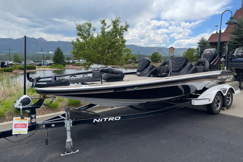 The Image of 2016 Nitro Z21 boat on trailer, parked outdoors with scenic mountain backdrop. - 0