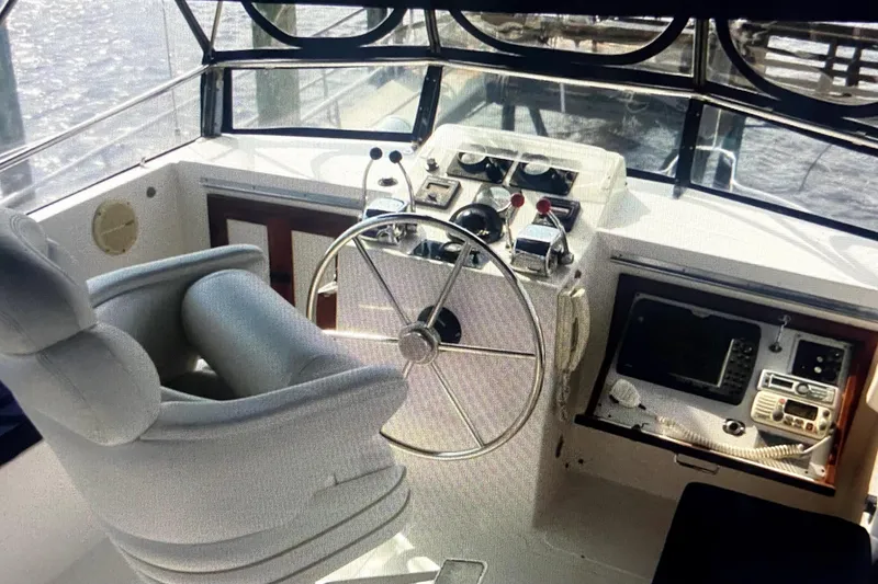Slide: The Image of 1987 Senator-Chien Hwa Futura Sundeck boat helm with steering wheel and navigation controls. - 2