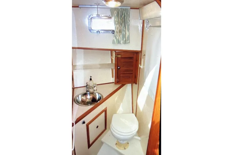 Slide: The Image of 1987 Senator-Chien Hwa Futura Sundeck yacht bathroom with sink, toilet, and wooden cabinetry. - 23