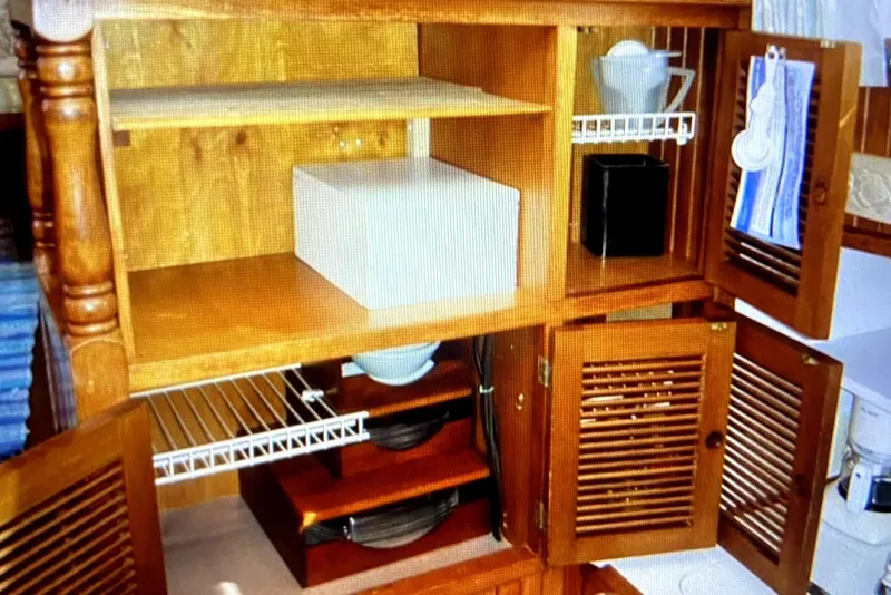 Slide: The Image of Wooden cabinet interior on 1987 Senator-Chien Hwa Futura sundeck, showcasing organized kitchenware. - 24