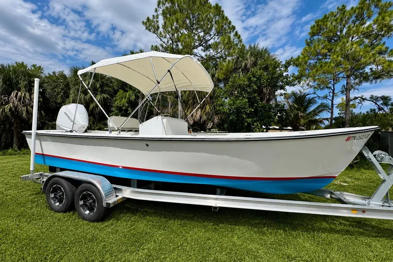 The Image of 2025 Rambo 22 Center Console boat on trailer, parked on grass with trees in background. - 0