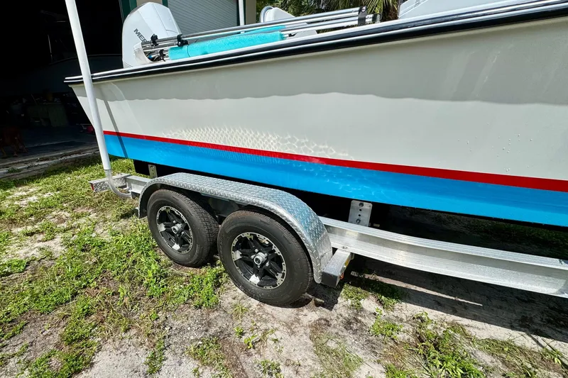 Slide: The Image of 2025 Rambo 22 Center Console boat on trailer, featuring vibrant blue and red accents. - 10