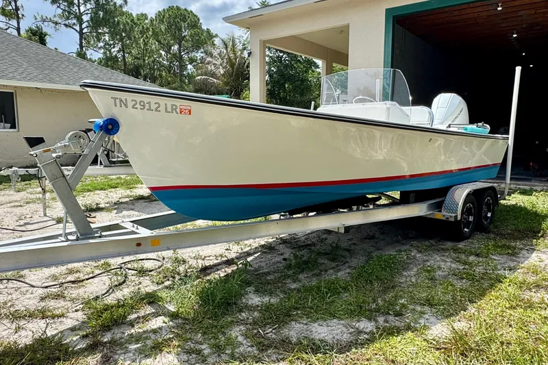 Slide: The Image of 2025 Rambo 22 Center Console boat on trailer, parked outdoors near a garage. - 13