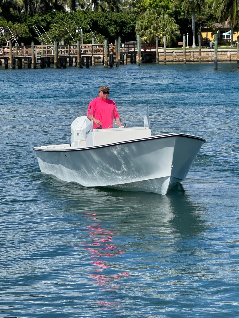 Slide: The Image of 2025 Rambo 22 Center Console boat cruising on a sunny day near a dock. - 18