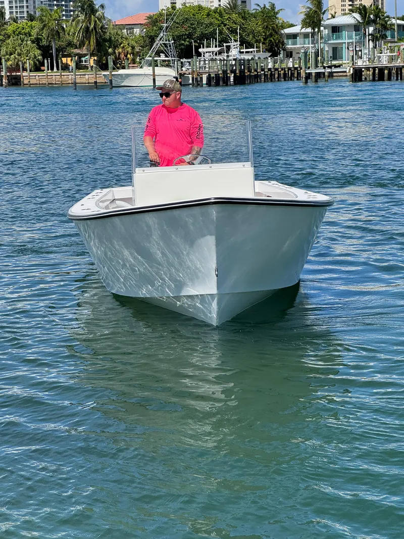 Slide: The Image of 2025 Rambo 22 Center Console boat on water, with person in pink shirt steering. - 19