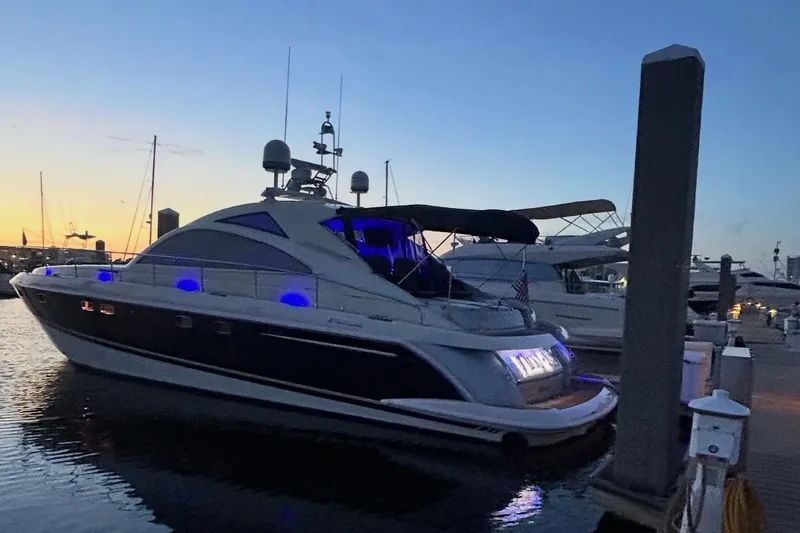 Slide: The Image of 2009 Fairline Targa 52 yacht docked at sunset with blue lights illuminating the deck. - 6