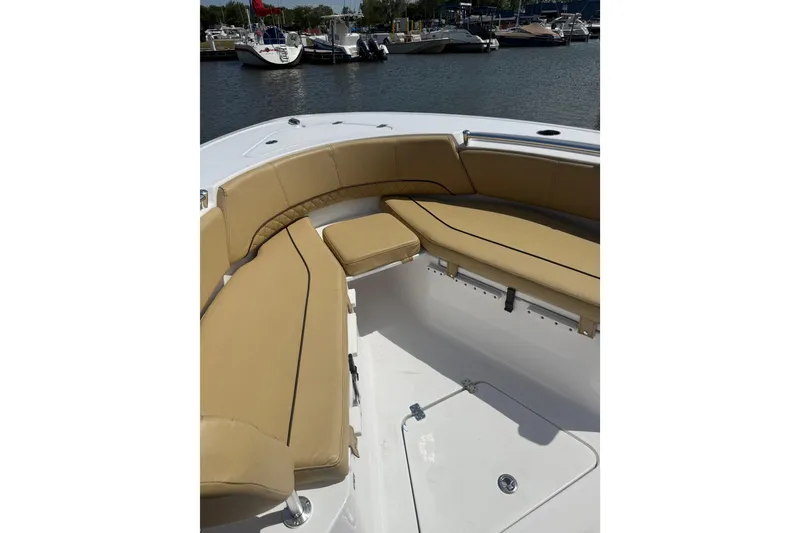 Slide: The Image of 2023 Sportsman Open 232 Center Console boat with tan seating at marina. - 28