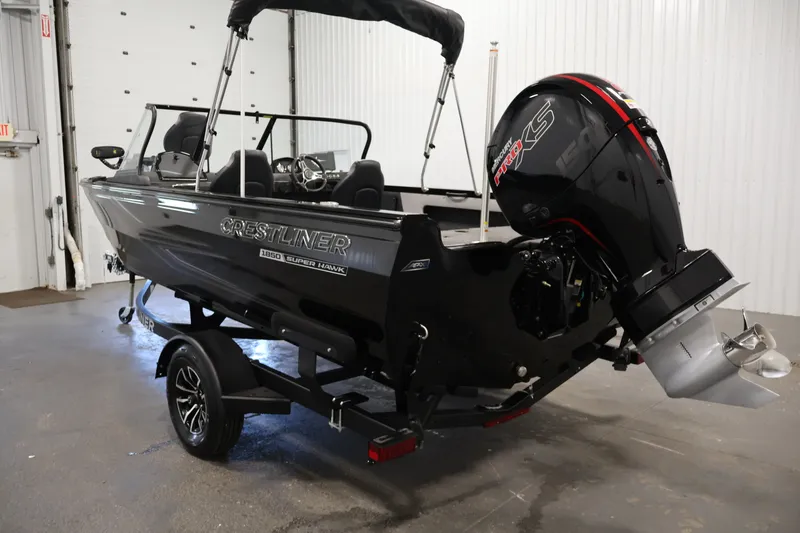 Slide: The Image of 2026 Crestliner 1850 Super Hawk WT JS boat with powerful outboard motor in a garage setting. - 9
