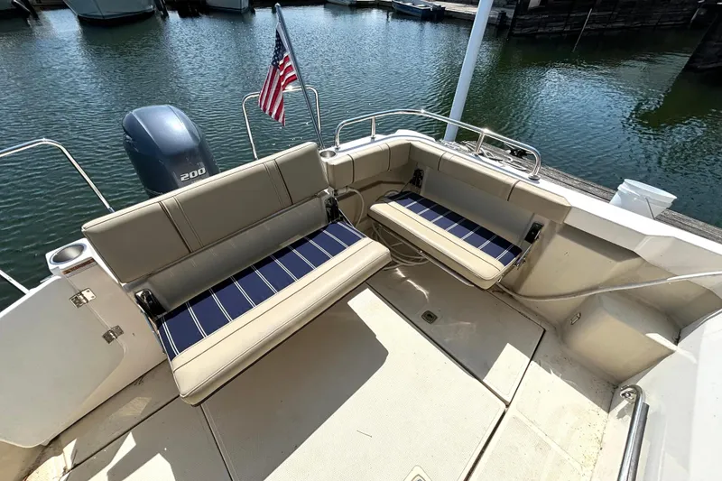 Slide: The Image of 2021 Ranger Tugs R-25 boat interior with seating and outboard motor at dock. - 14
