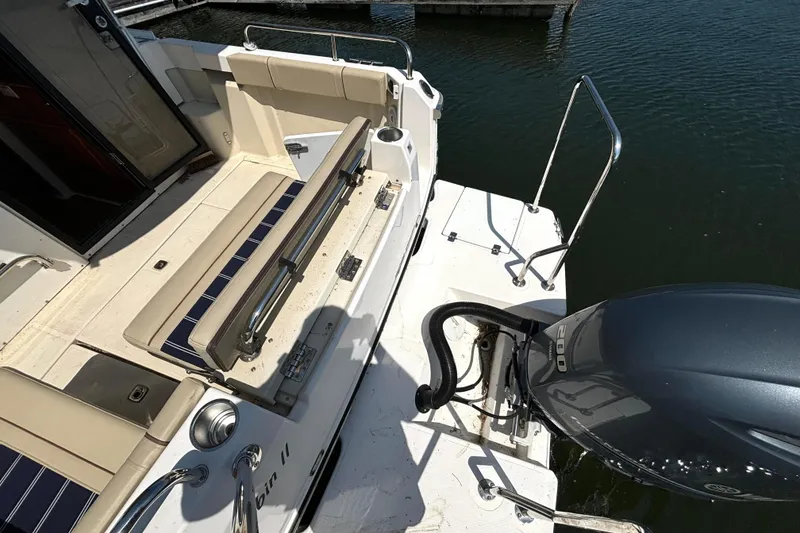 Slide: The Image of 2021 Ranger Tugs R-25 boat deck with seating and outboard motor. - 18