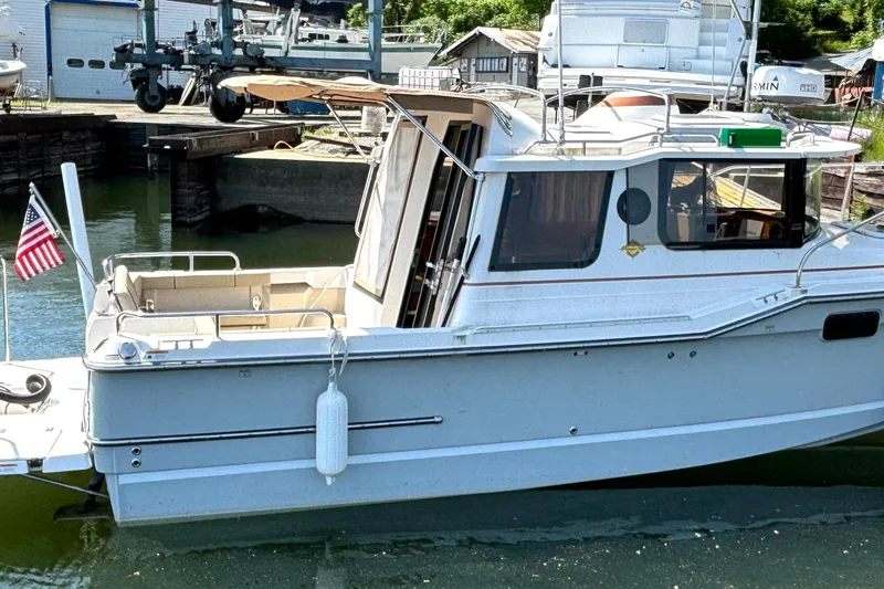 Slide: The Image of 2021 Ranger Tugs R-25 boat docked at a marina with an American flag. - 3