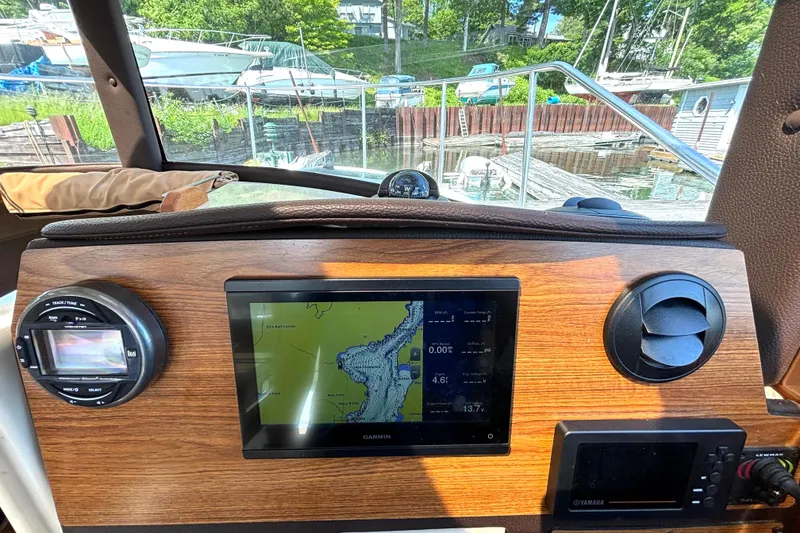 Slide: The Image of 2021 Ranger Tugs R-25 helm with Garmin navigation system, docked near boats. - 30