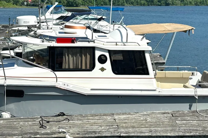 Slide: The Image of 2021 Ranger Tugs R-25 docked at a marina, surrounded by other boats. - 6