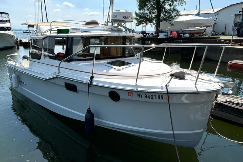 The Image of 2021 Ranger Tugs R-25 boat docked in a marina under a clear sky. - 1