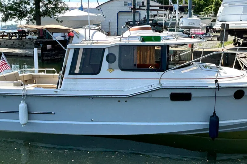 Slide: The Image of 2021 Ranger Tugs R-25 boat docked at marina with American flag. - 2