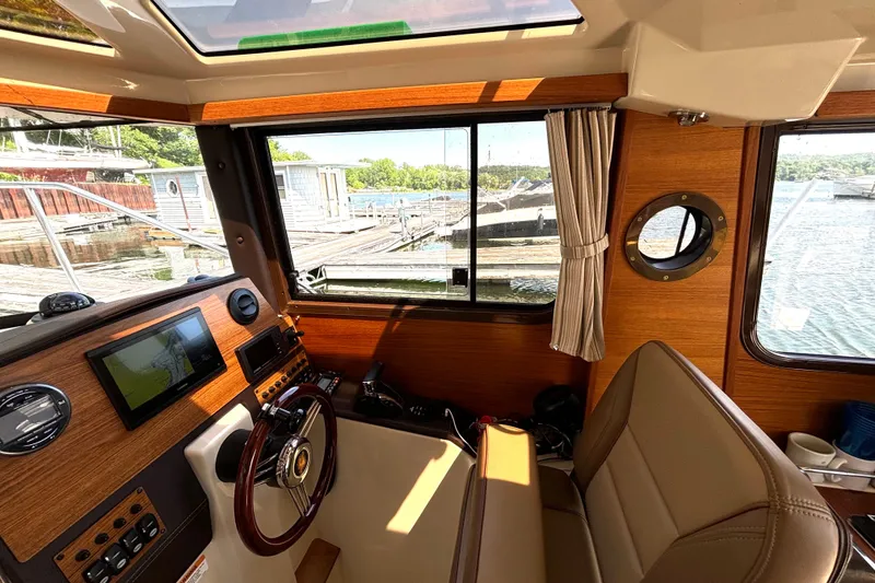 Slide: The Image of Interior of 2021 Ranger Tugs R-25 boat with helm, navigation screen, and window view. - 29