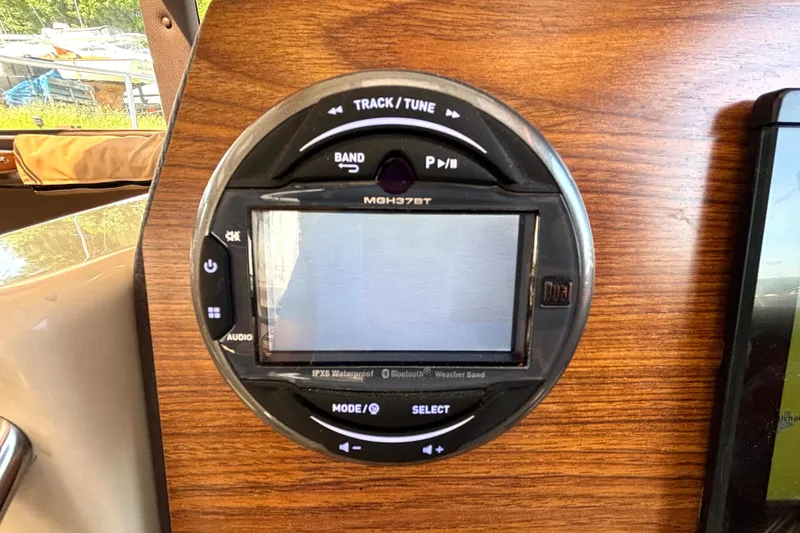 Slide: The Image of 2021 Ranger Tugs R-25 audio system with touchscreen and control buttons on wooden panel. - 31