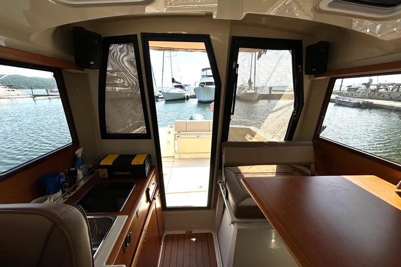 Slide: The Image of Interior view of 2021 Ranger Tugs R-25 boat with kitchen and seating area. - 38