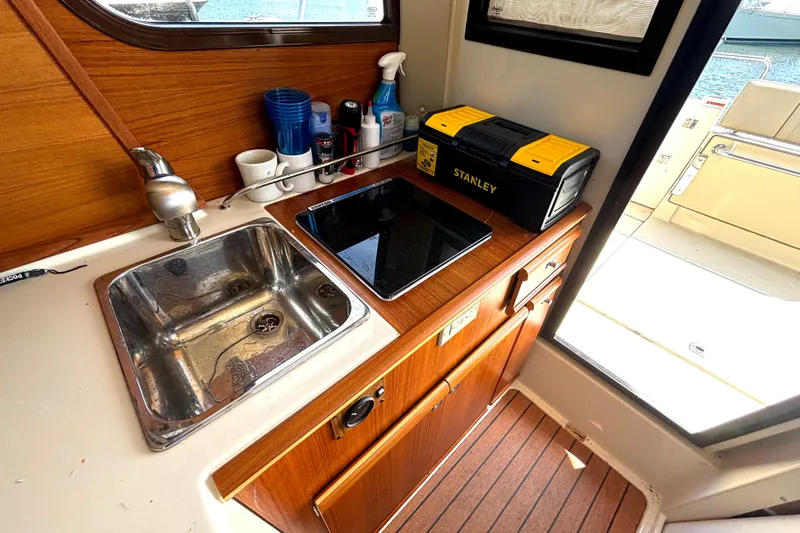 Slide: The Image of 2021 Ranger Tugs R-25 interior kitchen with sink, stove, and storage. - 39