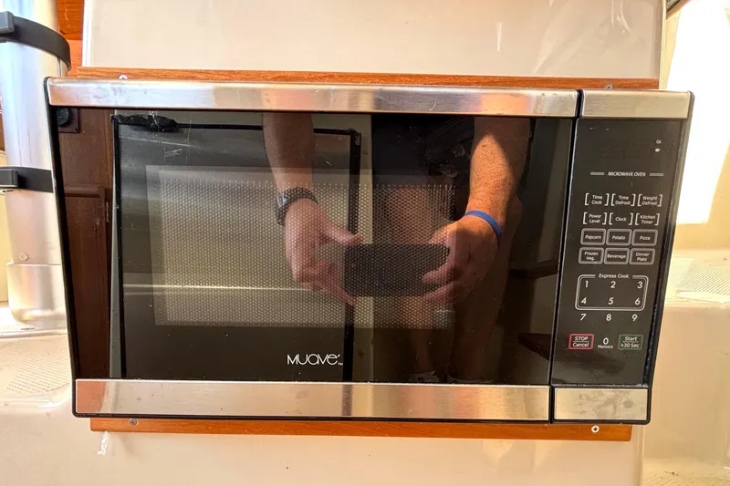 Slide: The Image of Microwave oven inside a 2021 Ranger Tugs R-25 boat, featuring digital controls and stainless steel finish. - 41