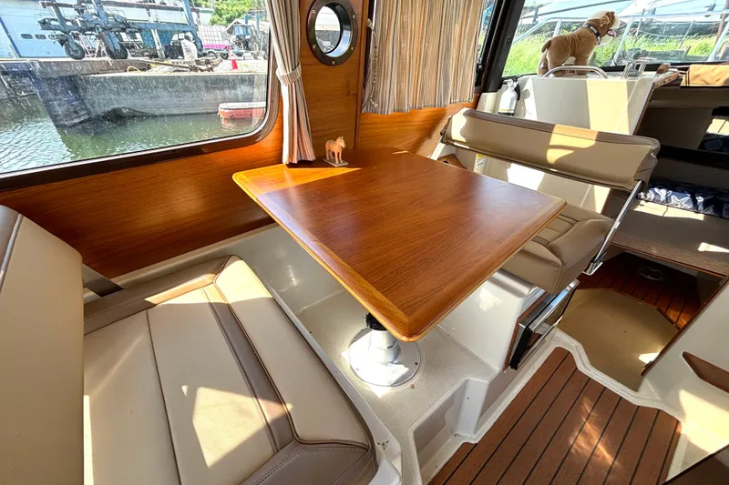 Slide: The Image of Interior of 2021 Ranger Tugs R-25 boat with wooden table and seating area. - 43