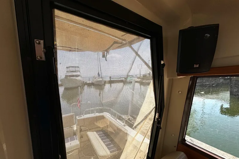 Slide: The Image of Interior view from a 2021 Ranger Tugs R-25, overlooking a marina through a screened window. - 45