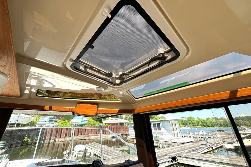 Slide: The Image of Interior view of 2021 Ranger Tugs R-25 boat with sunroof and dockside scenery. - 47