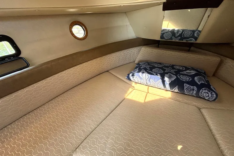 Slide: The Image of 2021 Ranger Tugs R-25 cabin interior with beige upholstery and nautical-themed pillow. - 50