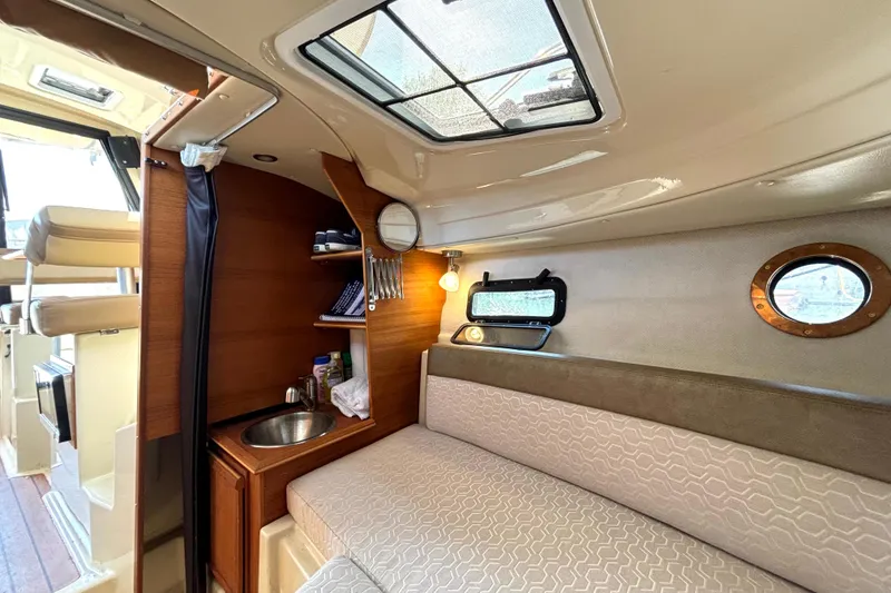 Slide: The Image of Interior of 2021 Ranger Tugs R-25, featuring cozy seating and compact kitchenette. - 51