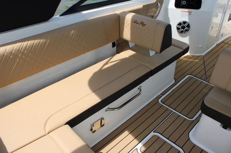 Slide: The Image of The image shows the interior of a 2026 Sea Ray SDX 250 Surf with beige upholstery and wood flooring. - 10
