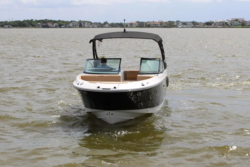 Slide: The Image of A 2026 Sea Ray SDX 250 Surf cruising on calm waters. It features a sleek design. - 6