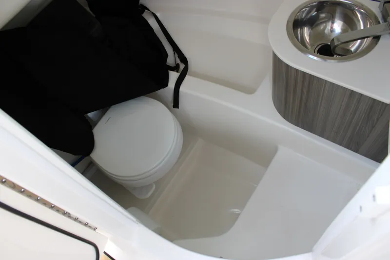 Slide: The Image of The image shows the bathroom of a 2026 Sea Ray SDX 250 Surf with a toilet and sink. - 17