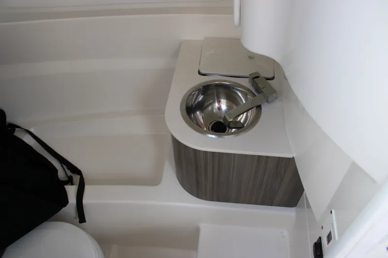 Slide: The Image of Interior view of a 2026 Sea Ray SDX 250 Surf with a sink and storage area. - 18