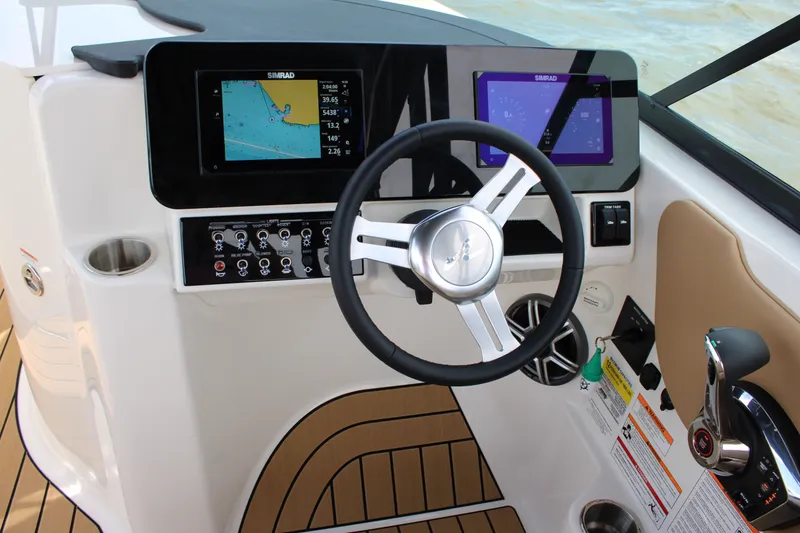 Slide: The Image of The image shows the cockpit of a Sea Ray SDX 250 Surf boat with modern instruments and a sleek steering wheel. - 30
