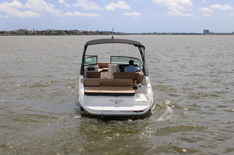 Slide: The Image of Sea Ray SDX 250 Surf 2026 on calm water with open deck and sunshade. - 2