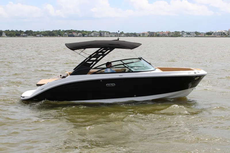 Slide: The Image of 2026 Sea Ray SDX 250 Surf on calm water, featuring a black hull and sunshade. - 4