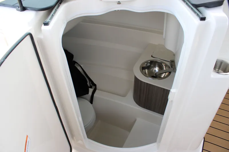 Slide: The Image of The image shows the interior of a 2026 Sea Ray SDX 250 Surf. There's a small toilet with a sink. - 19